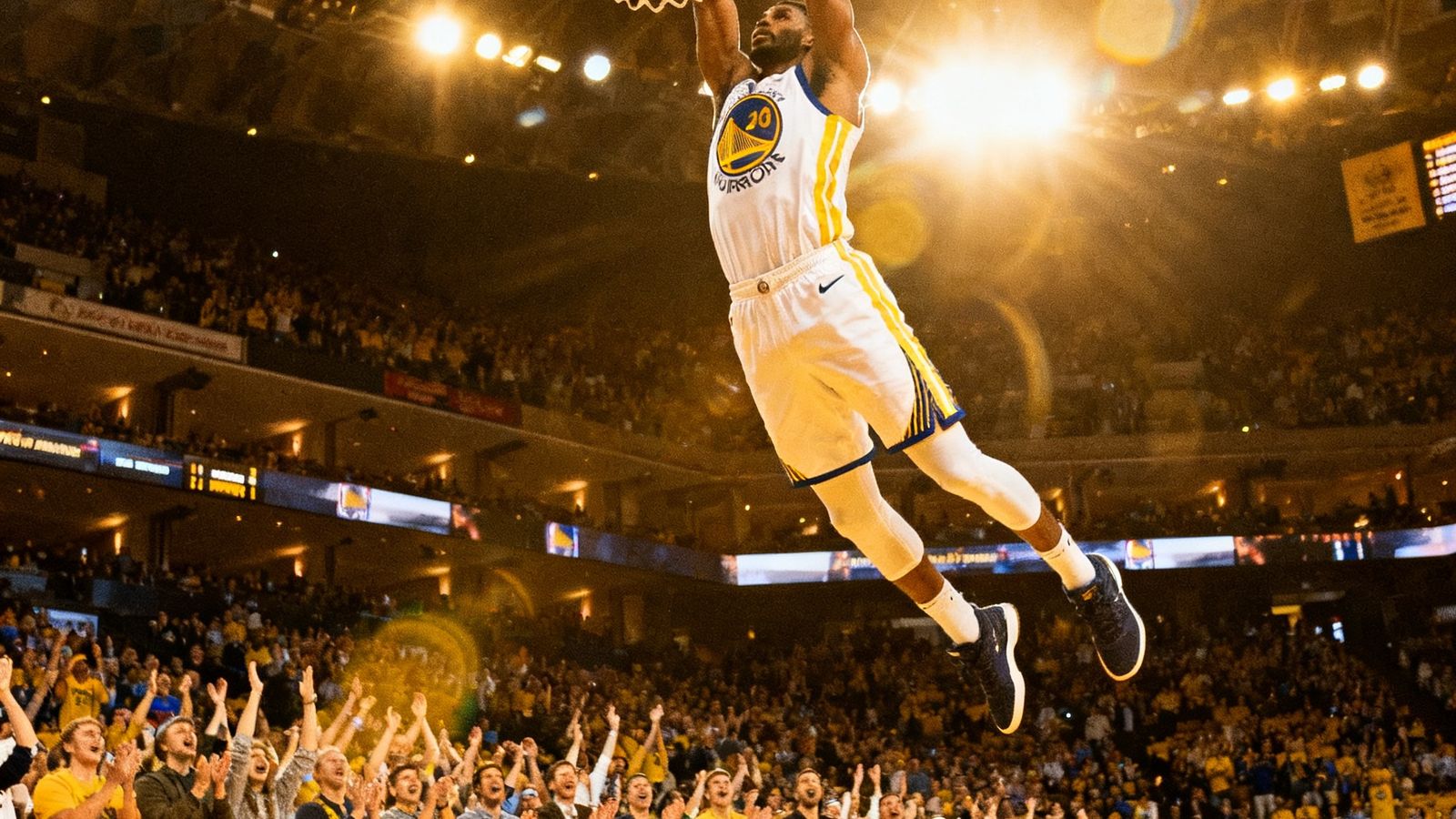NBA比赛中一记震撼的双手暴扣，球员身体舒展腾空，篮筐周围的观众集体起立欢呼